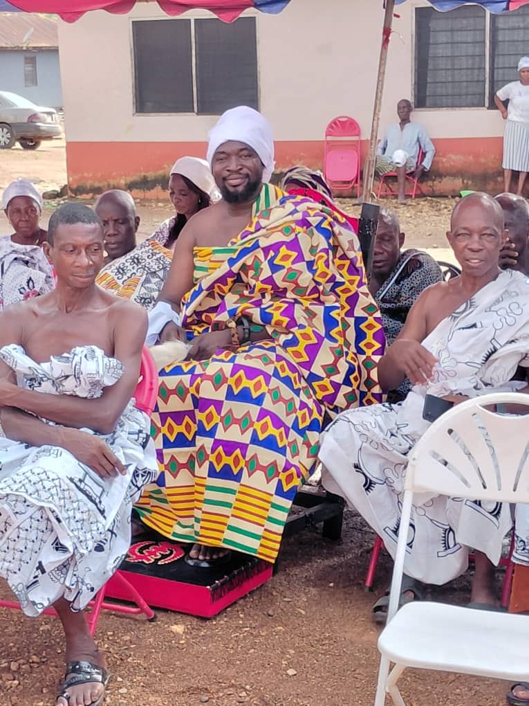 Togbe Edzeani V seated on the ceremonial stool in kente cloth, among the elders of the Fodome Traditional Council