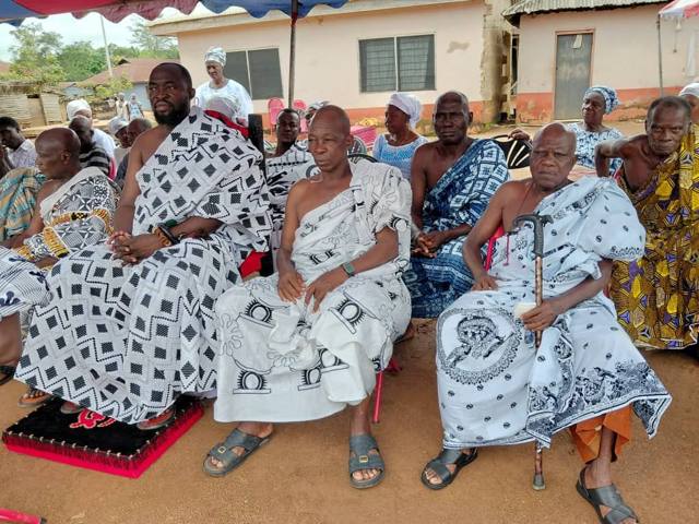 Elders seated together beneath the tent.