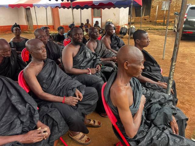 Elders in dark cloth seated in rows.