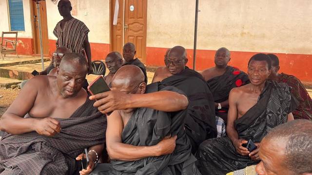 Elders seated closely together in black cloth.